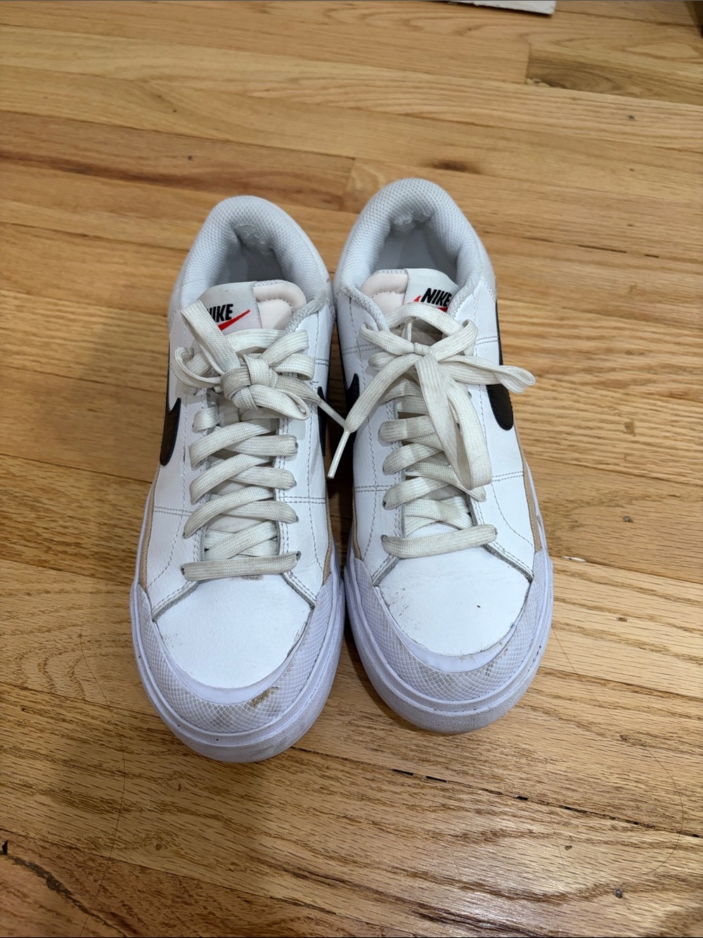 Nike White Low-Top Sneakers with Black Swoosh and Red Tongue Logo